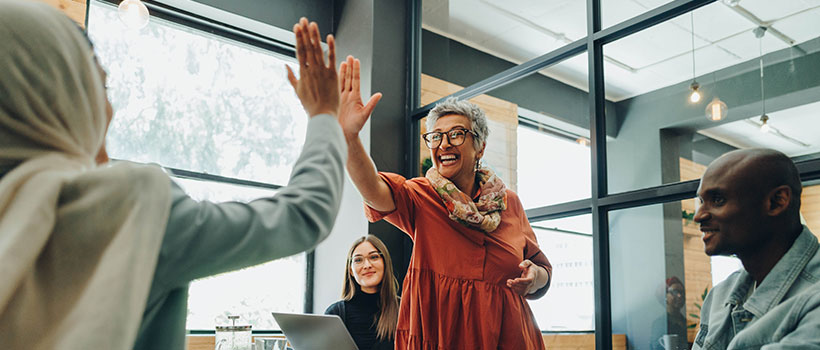 A photo of employees slapping each other five.